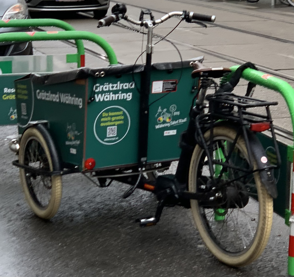 Dunkelgrünes CargoBike angekettet an einen Fahrradständer