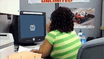Woman sitting in front of a computer. Suddenly a Mail-Icon appears on screen. The woman jumps up from her chair